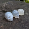 Set di tre teschi scolpiti in cristallo naturale lucido, tonalità bianco e grigio traslucido - Agata