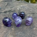 Cinque teschi in cristallo di ametista con trame minerali viola naturali e lucide - Ametista