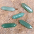 Cinque cristalli di avventurina verde a doppia punta esagonale su una superficie rocciosa - Avventurina Verde