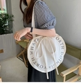 Detail der runden weißen Canvas-Schultertasche mit schwarzem Textdruck und Kordelzug-Schleife - Runder englischer Druck Schulter Off-White