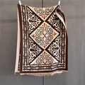Close-up of geometric jacquard knit pattern with tassels on vintage ethnic shawl - Coffee