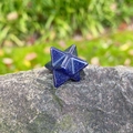 Blue Goldstone Merkaba Star crystal carving on natural rock with green background - Blue Sand Stone (Synthetic)