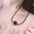 Elegant natural red agate bead necklace with gold accents on a minimalist black cord - Small Round Bead Necklace / Red