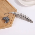 Silver metal feather bookmark with a grey marble moon pendant on a wooden tray - Picasso Stone
