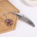 Silver feather bookmark with natural pink stone moon pendant in a wooden tray - Rhodonite