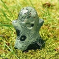 Polished green jasper ghost stone carving on mossy lawn for Halloween decor - Sparrow Stone