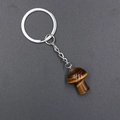 Tiger eye stone mushroom keychain with silver metal ring on dark textured background - Tiger's Eye