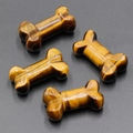 Polished tiger eye stone bone-shaped ornaments with natural chatoyancy and golden brown luster - Tiger's Eye