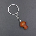 Red agate mushroom pendant keychain with a silver metal ring on a dark background - Red Agate