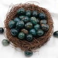 Polished egg-shaped green agate gemstone crystal displayed in a rustic bird nest - Indian Agate (1pc)