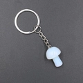 White mushroom crystal keychain with silver metal ring and chain on dark gray background - Opalite