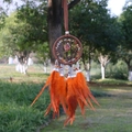 Atrapasueños bohemio con plumas naranjas y piedras naturales en un jardín - Ágata roja