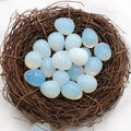 Egg shaped opalite crystal stone with iridescent blue glow in a bird nest prop - Opalite (Single Piece) (Synthetic)