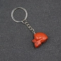 Carved red stone skull keychain with a silver metal ring and chain on a textured background - Red Jasper