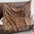 Nahaufnahme eines braunen Vintage-Paisley-Halstuchs mit weißen Blumenmustern auf Leder - 90x90cm / Kaffee