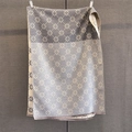 Détail d'une écharpe en jacquard réversible avec motifs de trèfles et finitions à franges - Gris