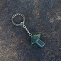 Natural green aventurine mushroom keychain with silver chain on stone background - India Agate
