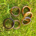 Set of six natural tiger's eye stone rings with golden brown textures on moss background - Tiger's Eye
