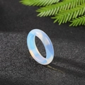 Minimalist translucent opalite gemstone ring with soft blue glow on black background - Synthetic Opal