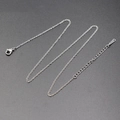 Collana a catena ad O d'argento con chiusura a moschettone ed estensione su sfondo grigio - Argento