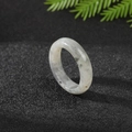 Natural gray-white agate stone ring with black inclusions on dark sandy texture - Labradorite