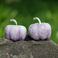 Purple natural stone pumpkin ornament with silver metal stem on a natural rock surface - Phosphosiderite
