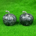 Set of two labradorite crystal pumpkins with silver metal stems on green grass background - Larvikite
