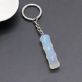 Bamboo shaped opal pendant keychain with silver metal ring on a black textured background - Opal 1Pc (Synthetic)