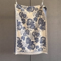 Dettaglio del motivo jacquard a peonia retrò e delle nappe sottili su questa sciarpa - Blu