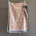 Detail von Paisley-Muster und weißen Quasten an einem dicken lachsorangen Schal - Blau Rosa