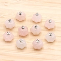 Translucent pink crystal pumpkin pendants with silver loops on light wood surface - Rose Quartz