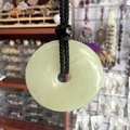 Light green crystal donut pendant with black hand-woven cord and obsidian bead - Xiu Jade