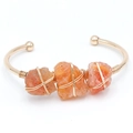 Goldenes C-Manschettenarmband mit drei orangefarbenen Natursteinen und Wickeloptik - Roter Achat