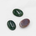Polished oval cabochon moss agate gemstones in deep green and reddish brown hues - India Agate