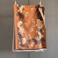 Dettaglio di sciarpa in cashmere arancione con motivi a foglie di ginkgo e frange - Ambra