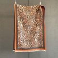 Close-up of paisley pattern scarf with orange tassels and integrated CO letter design - Orange Red