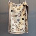 Detailed texture of beige floral scarf with bow prints and delicate fringed edges - Tan