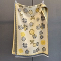 Detail of floral and bow print scarf showing soft cashmere-like texture and fringed edges - Yellow