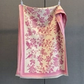 Detail of pink floral and bird print scarf with delicate fringes on a textured background - Pink