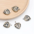 Dalmatian Jasper heart pendants with silver metal clasps on a rustic wooden tray - Dalmatian Jasper