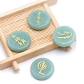 Piedras de aventurina verde con símbolos de Reiki dorados sobre estera de bambú - Aventurina Verde