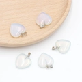 Heart-shaped opal stone pendant with silver clasp on a minimalist wooden tray - Synthetic Opal