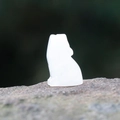 Loup en cristal naturel translucide blanc sculpté posé sur un socle en pierre brute - Cristal blanc