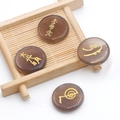 Piedra de ágata marrón pulida con símbolos de Reiki grabados en oro en superficie redonda - Ágata Gris