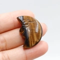 Tiger eye stone crescent moon face carving with golden brown chatoyant texture - Tiger's Eye