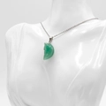Carved green crystal moon face pendant necklace on a white jewelry display bust - Green Aventurine