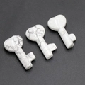 Three heart-shaped white turquoise key ornaments with natural grey marble texture - Howlite