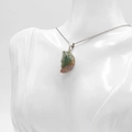 Engraved face moon pendant in natural green stone with silver chain on model - India Agate