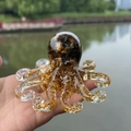 Tiger eye crystal octopus resin figurine with gold foil accents held outdoors - Tiger's Eye
