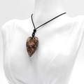 Polished heart-shaped rhodonite crystal pendant with pink and black natural texture - Rhodonite